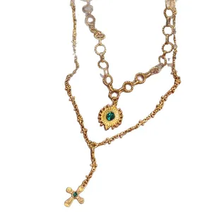 Collana vintage a doppio strato in oro con pendenti a sole e croce e pietre verdi