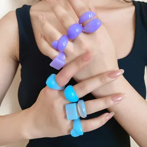 Detailed close-up showing multiple blue and purple resin geometric rings on fingers