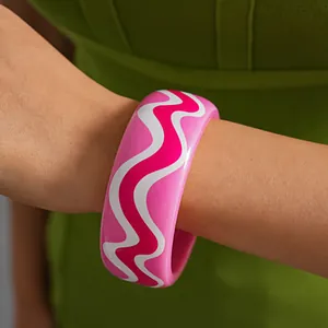 Vibrant pink dopamine resin bangle with white wavy patterns shown on a model arm