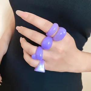 Close-up of trendy chunky purple resin rings with wrinkled geometric textures