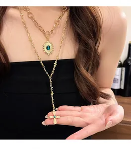 Dettaglio macro di una collana dorata a strati con pendenti a croce e a forma di sole