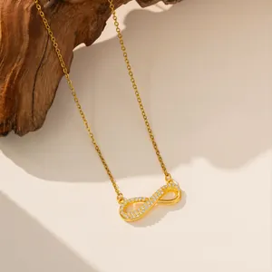 Detailansicht der goldenen Infinity-Halskette mit funkelnden Zirkonia-Steinen besetzt.