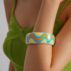 Detailed macro view of colorful resin wave patterned dopamine style bangle on arm