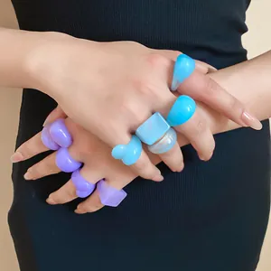 Close-up view of vibrant chunky resin geometric rings in pastel blue and lavender purple tones
