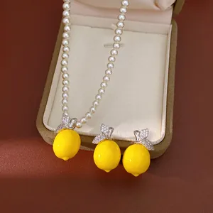 Vue détaillée de l'ensemble de bijoux citron avec collier et boucles d'oreilles en zircons.