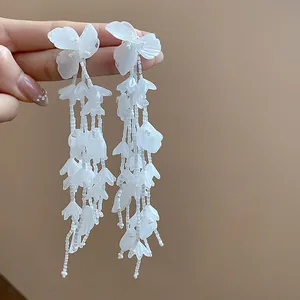 Nahaufnahme eleganter weißer Glasblumen-Quasten mit 18 Karat vergoldeten Silbernadeln