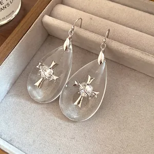Elegant clear resin teardrop drop earrings with silver cross and heart design detail