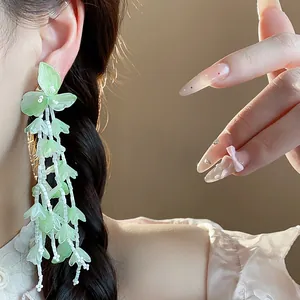 Detailansicht der eleganten grünen Glasblumen-Quastenohrringe mit 18k Goldbeschichtung