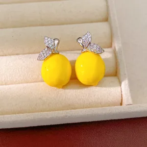 Gros plan détaillé de boucles d'oreilles citron jaunes avec des feuilles en zircone
