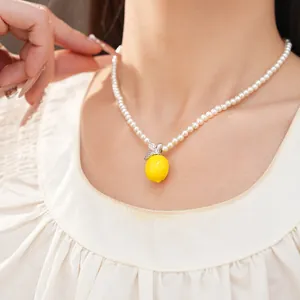 Gros plan détaillé d'un collier de perles avec un pendentif citron sur le cou d'un mannequin