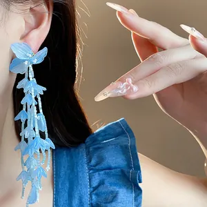 Nahaufnahme eleganter blauer Glasblumen-Quastenohrringe mit langen hängenden Perlen