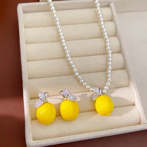 Vue détaillée d'un ensemble de bijoux collier et boucles d'oreilles citron en résine.