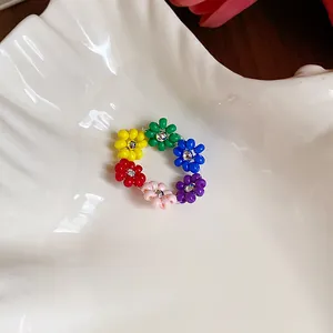 Gros plan détaillé d'une bague fleur en perles colorées faite main sur un plateau
