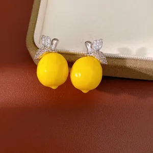 Vue macro d'un pendentif citron en résine jaune avec des feuilles de zircone étincelantes.