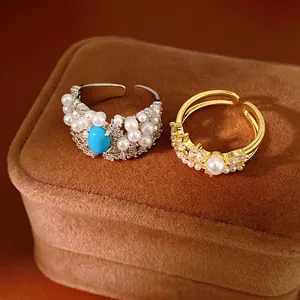 Elegant court style rings with pearls and zircons displayed on a velvet jewelry box