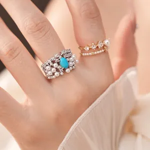 Vintage silver ring with blue oval stone and pearls, featuring elegant zircon accents