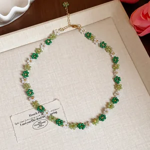 Vue détaillée d'un collier de fleurs en perles de verre fait main vert et blanc été