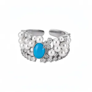 Vintage silver open ring featuring pearls, sparkling zircons, and an oval blue stone