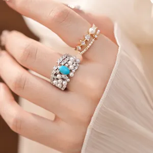 Elegant close-up detail of vintage style zircon and pearl rings set on a female finger