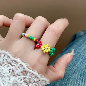 Détail en gros plan d'une bague en perles de verre colorées avec fleurs et strass brillants