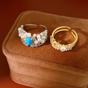 Macro detail of palace style rings featuring blue stone, pearls, and zircons on a velvet box