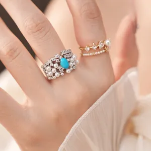 Close-up of elegant palace style silver and gold rings with blue stone and white pearls