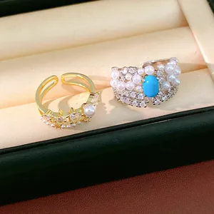 Close-up of elegant palace style rings featuring pearls, zircons and turquoise