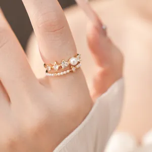 Detailed macro shot of an elegant gold-toned ring featuring heart zircons and a pearl