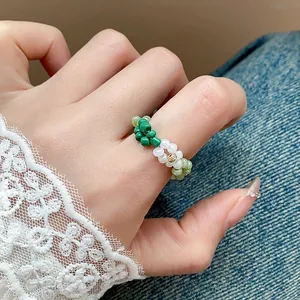 Vue rapprochée de la bague fleur en perles de verre colorées faite à la main au doigt