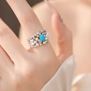 Detailed close-up view of a vintage palace style ring with turquoise and white pearls