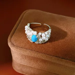 Detailed view of a vintage palace style ring with blue stone, pearls and zircons