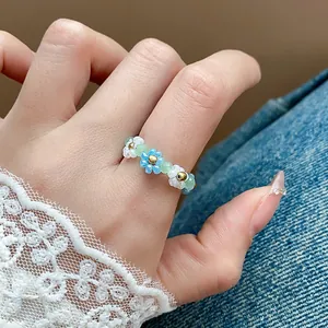 Vue détaillée d'une bague fleurie en perles de verre pour l'été en bleu et blanc chic