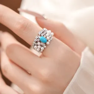 Close-up of an elegant palace style ring with pearls, zircons and turquoise stone