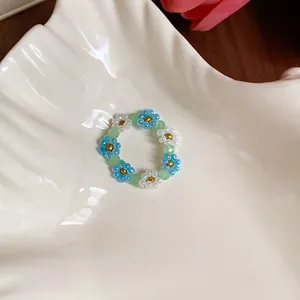 Détail d'une bague de fleurs en perles faite main aux couleurs d'été bleu et blanc