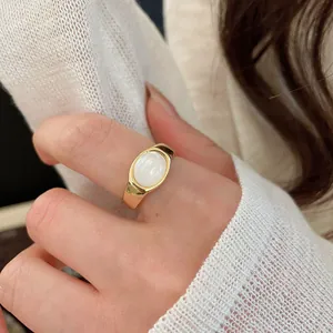 Detailed close-up of a minimalist 18k gold plated open ring featuring a white oval resin stone