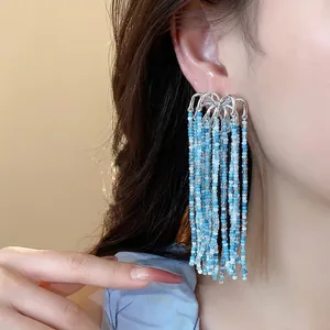 Handmade firework style beaded tassel earrings with blue glass beads on silver posts
