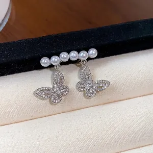 Silver needle hollow butterfly stud earrings with elegant pearls for a French chic look