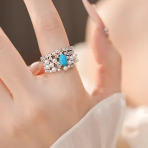 Exquisite vintage style ring featuring pearls, turquoise, and zircon on model hand