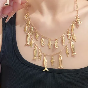 Détail d'un collier doré à double rangée orné de breloques en forme de poisson.