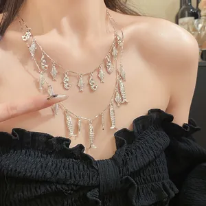 Gros plan d'un collier vintage à deux rangs en argent avec de petits charms de poissons