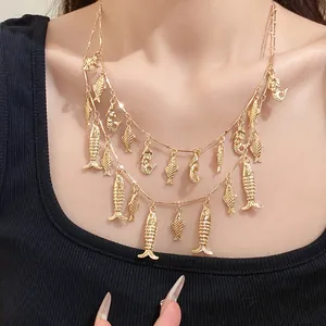 Vue détaillée d'un collier doré à double rangée orné de charmants pendentifs poissons