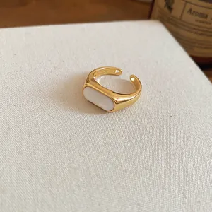Detail view of a minimalist 18k gold plated open ring featuring a white resin inlay.