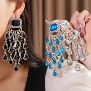 Detail view of oversized rhinestone chandelier earrings in black, blue, and clear