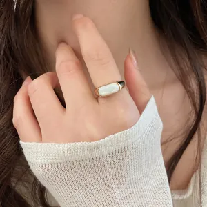 Elegant 18k gold plated open ring with oval white resin inlay worn on model finger