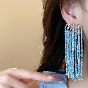 Close-up view of blue glass bead tassel earrings with fireworks inspired design