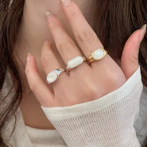 Detailed close-up showing minimalist 18k gold plated and silver resin rings on a model hand