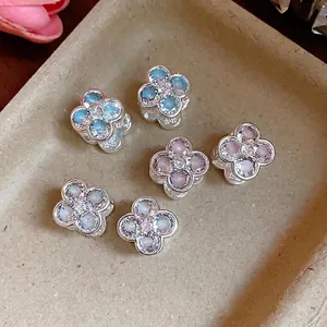 Elegant Korean style zircon flower earrings in multiple colors on a textured tray