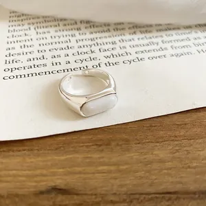 Detailed macro view of a silver minimalist open ring featuring a white resin inlay