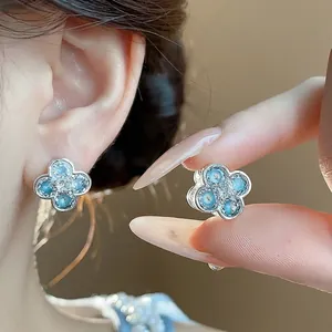 Elegant silver-toned floral stud earrings with blue enamel petals and sparkling zircon center