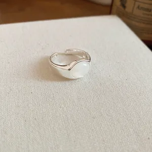 Elegant close-up of adjustable silver-plated ring with a smooth oval white resin stone center.